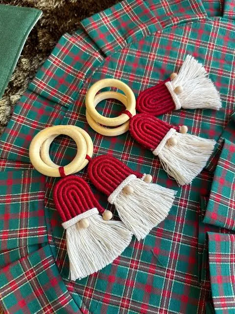 Porta-guardanapos de madera con dije de gnomo navideño sobre mantel a cuadros
