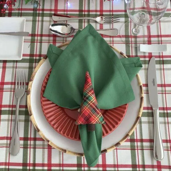Aro de guardanapo de tela a cuadros con arbolito de Navidad sobre servilleta verde