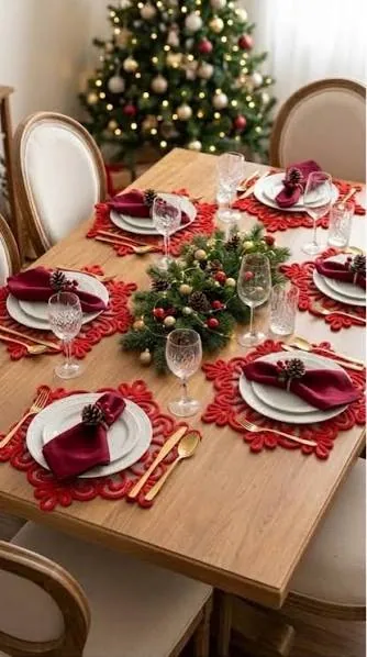 Mesa navideña con manteles individuales rojos de encaje y servilletas burdeos
